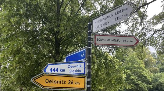 Znak drogowy z odległościami do miast parntnerskich Rehau.